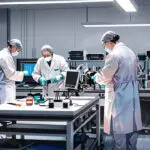 Laboratorio moderno con equipos de biotecnología e investigadores trabajando con pantallas digitales