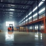 Interior de una nave industrial moderna con carretillas elevadoras remanufacturadas y maquinaria de precisión