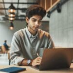 Retrato de un emprendedor joven trabajando con su laptop en un espacio de coworking moderno