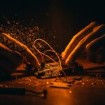 Manos ensamblando un prototipo de placa electrónica de hardware abierto, representando la historia y controversias de Arduino y la innovación tecnológica open source.