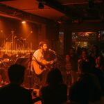 Emprendimiento musical en Bogotá con músicos emergentes actuando en Idilio Bar, un espacio cultural que apoya talentos locales.