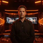 Brendan Carr en estudio de broadcasting con simbolismos patrióticos, reflejando la propuesta de programación patriótica de la FCC para emisoras en EE.UU.