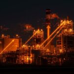 Planta de gas natural iluminada con tonos naranja y negro, simbolizando inversión energética y desarrollo tecnológico en startups.