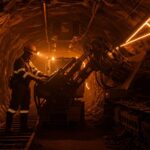 Operario minero usando exoesqueleto industrial en proyecto El Pachón, destacando innovación tecnológica y salud ocupacional en minería LatAm.