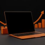 MacBook Neo 2026 destacado en luz naranja y negro, simbolizando laptop económica y tendencias del mercado tecnológico.