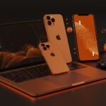 Dispositivos Apple MacBook Neo, iPhone 17e y AirPods Max 2 en un entorno tecnológico con iluminación naranja y negra, destacando las novedades Apple marzo 2026 para startups en LATAM.