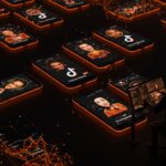 Telefonos con avatares de influencers IA en TikTok hackeados por hacker mostrando fraude en redes sociales y startup Doublespeed de a16z.