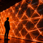 Experto en ciberseguridad frente a una red digital bloqueada por guardrails de IA Claude Fable 5, representando los desafíos del desarrollo software en 2026.