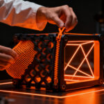 Ingeniero del MIT CSAIL manipulando una estructura de impresión 3D Y-Zipper que cambia de flexible a rígida, innovación en manufactura avanzada.