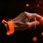 Adulto mayor utilizando una pulsera inteligente con tecnología de voz e inteligencia artificial, mejorando la salud y accesibilidad.