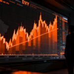 Analista financiero observando gráficos de mercado y tendencias del dólar, representando el impacto macroeconómico en startups y mercados emergentes.
